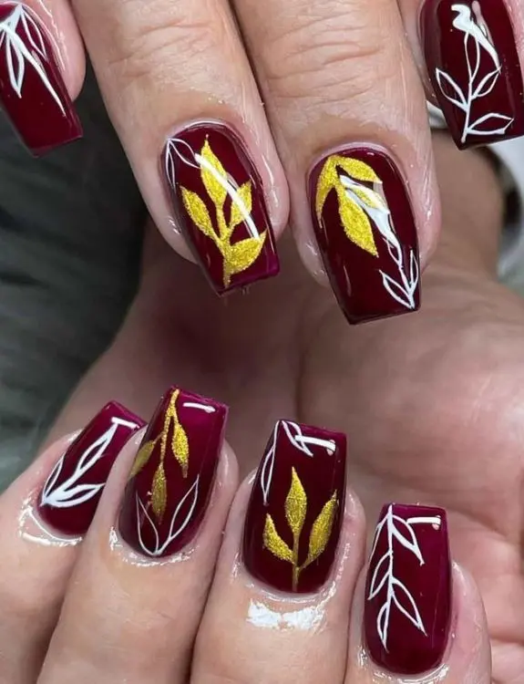 Golden Leaves on burgundy nails 